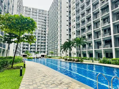 a swimming pool in front of some tall buildings at Shore Bliss Staycation MOA in Manila