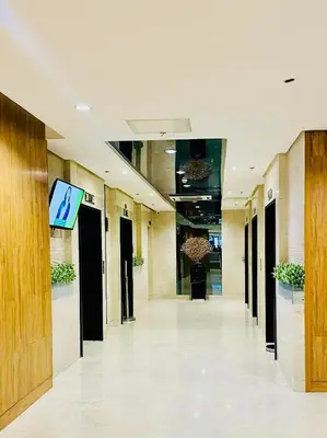 a hallway of a building with a tv on the wall at Shore Bliss Staycation MOA in Manila