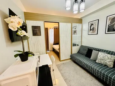 a living room with a couch and a table at Shore Bliss Staycation MOA in Manila