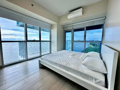 a bedroom with large windows and a bed with white pillows at Modern 1Bedroom Direct ManilaBay SeaView Okada Airport Spacious in Manila