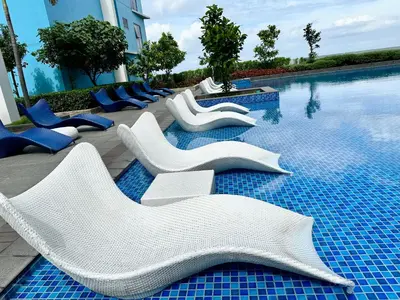a swimming pool with white lounge chairs next to the water at Modern 1Bedroom Direct ManilaBay SeaView Okada Airport Spacious in Manila