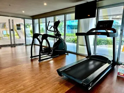 a gym with two treadmill machines in a room with windows at Modern 1Bedroom Direct ManilaBay SeaView Okada Airport Spacious in Manila