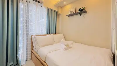 a small bedroom with a bed and a window at 1 Bedroom Apartment in Pasay near MOA in Manila