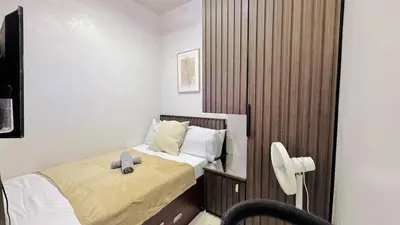 a bedroom with a bed with a hat on it at Cozy 1 Bedroom near MOA in Manila