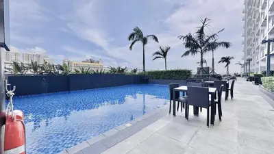a table and chairs next to a swimming pool at Cozy 1 Bedroom near MOA in Manila