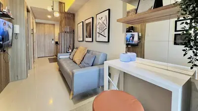 a living room with a couch and a table at Cozy 1 Bedroom near MOA in Manila