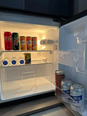 an open refrigerator with drinks and cans of soda at GreyKey Stays at the 34th in Manila