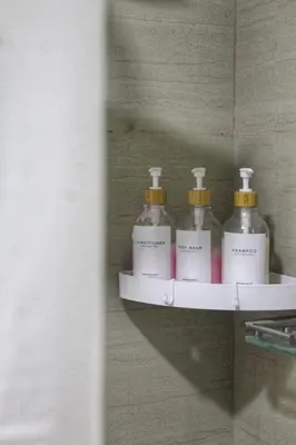 a shelf with four bottles of soap on a wall at Japandi - Inspired Staycation MOA Pasay City in Manila
