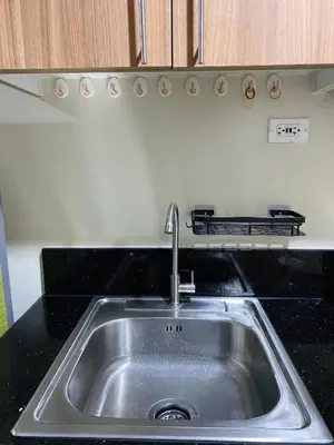 a stainless steel sink in a kitchen at Cabin and a cozy stay near MOA in Manila