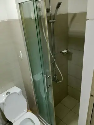 a bathroom with a shower and a toilet at Ambulinog in Manila