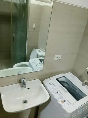 a bathroom with a sink and a mirror and a toilet at Ambulinog in Manila
