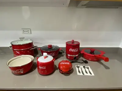 a group of red pots and pans on a counter at MOA Home For Family Trips & Getaways Kitchen-505 in Manila