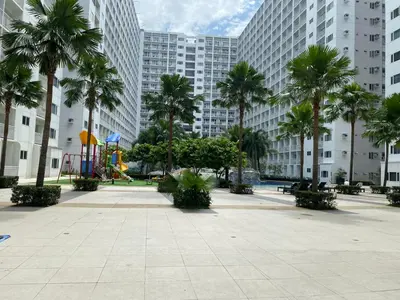 a park with a playground and palm trees and buildings at MOA Home For Family Trips & Getaways Kitchen-505 in Manila