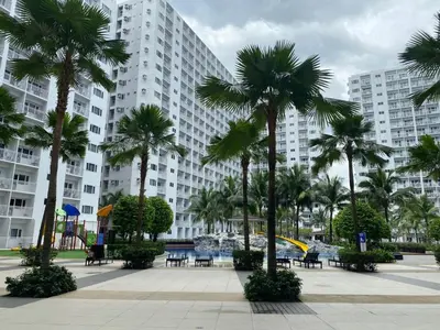 a large building with palm trees in front of it at MOA Home For Family Trips & Getaways Kitchen-505 in Manila