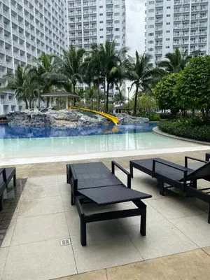 a large swimming pool with benches in front of buildings at MOA Home For Family Trips & Getaways Kitchen-505 in Manila