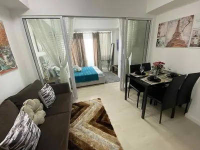 a living room with a couch and a table and a bedroom at Condo in Paranaque City Homes Azure in Manila