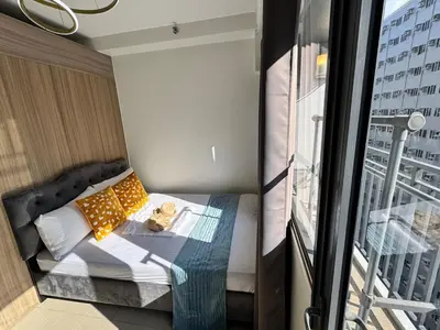 a small bed in a room with a balcony at Room 1469 Shore 2 Residences Near Airport, MOA by Prime Stay MOA in Manila