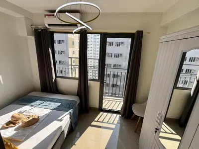 a bedroom with a bed and a large window at Room 1469 Shore 2 Residences Near Airport, MOA by Prime Stay MOA in Manila