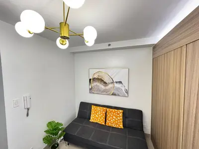 a living room with a black couch and a ceiling at Room 1469 Shore 2 Residences Near Airport, MOA by Prime Stay MOA in Manila