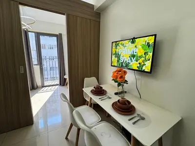 a room with a white table with chairs and a tv at Room 1469 Shore 2 Residences Near Airport, MOA by Prime Stay MOA in Manila