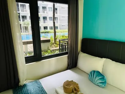 a room with a bed with a window and a pillow at Shore 3 Residences Poolside Room 245 by Prime Stay MOA in Manila