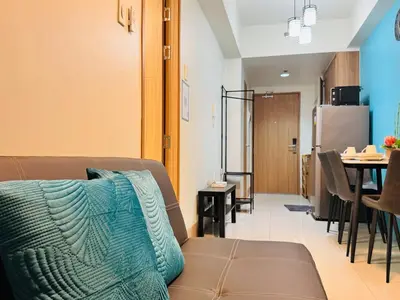 a living room with a couch and a dining room at Shore 3 Residences Poolside Room 245 by Prime Stay MOA in Manila