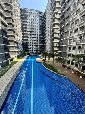 an empty swimming pool in the middle of two tall buildings at Shore 3 Residences Poolside Room 245 by Prime Stay MOA in Manila