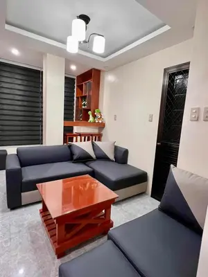 a living room with a blue couch and a table at Apartment Taguig Makati staycation with parking in Manila
