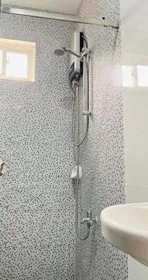 a shower in a bathroom with a sink at Apartment Taguig Makati staycation with parking in Manila