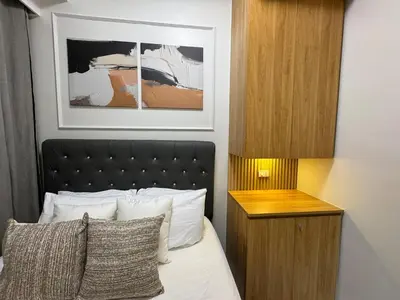 a bedroom with a bed with a black headboard at Room 1691 Shore 3 Residences infront of SM MOA by Prime Stay in Manila