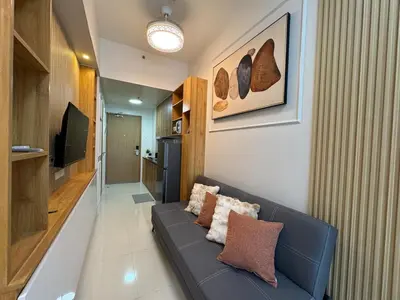 a living room with a blue couch and a television at Room 1691 Shore 3 Residences infront of SM MOA by Prime Stay in Manila