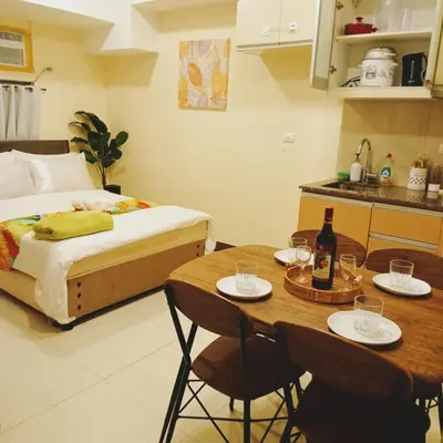 a bedroom with a bed and a table with two chairs at The Viceroy Tower Staycation at McKinley Hills Taguig in Manila