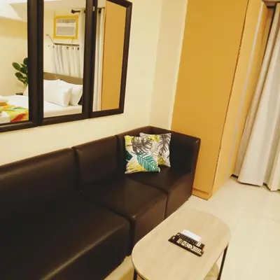 a living room with a couch and a table and a mirror at The Viceroy Tower Staycation at McKinley Hills Taguig in Manila