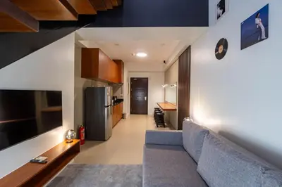a living room with a couch and a kitchen at Stunning View Loft Type 1 BR in Circulo Verde near Bridgetowne, Eastwood Fast Wi-Fi in Manila