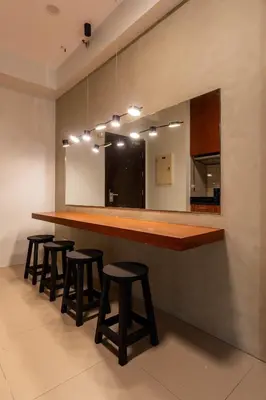 a kitchen with a long wooden counter with stools at Stunning View Loft Type 1 BR in Circulo Verde near Bridgetowne, Eastwood Fast Wi-Fi in Manila
