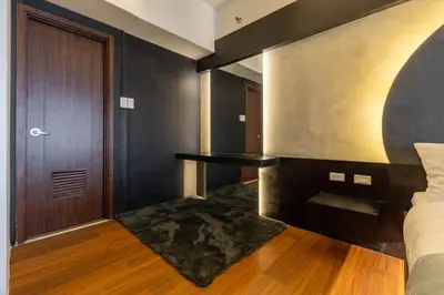 a bedroom with a bed and a wooden door at Stunning View Loft Type 1 BR in Circulo Verde near Bridgetowne, Eastwood Fast Wi-Fi in Manila