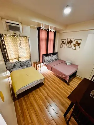a bedroom with two beds and a table and a desk at JFam Suites, C2-5F 1BR , Up To 6 Pax in Biñan