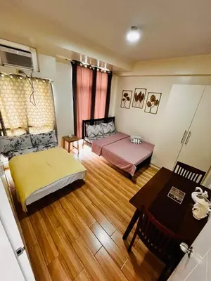 a living room with two beds and a table at JFam Suites, C2-5F 1BR , Up To 6 Pax in Biñan