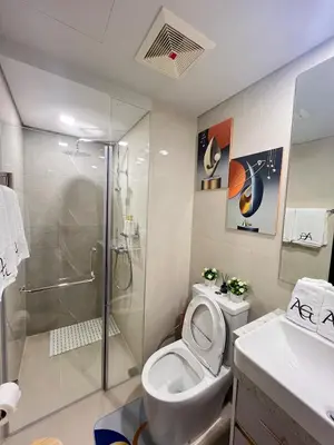a bathroom with a shower and a toilet and a sink at Luxe 1BR Condo - Near BGC & Venice Grand Canal in Manila