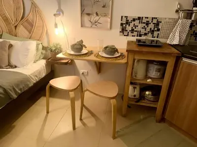 a small room with a bed and a table and two chairs at Captivating Crib in the Metro in Manila