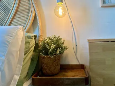 a plant in a wooden box next to a bed at Captivating Crib in the Metro in Manila