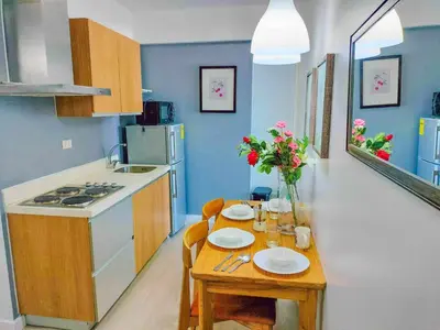a small kitchen with a table with plates and flowers at Azure Place Maui 8th floor in Manila