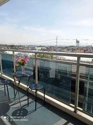 a balcony with a table with flowers on it at Azure Place Maui 8th floor in Manila