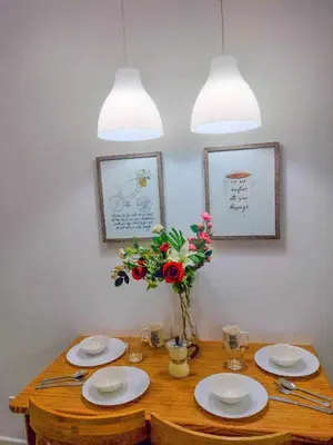 a dining room table with plates and a vase of flowers at Azure Place Maui 8th floor in Manila