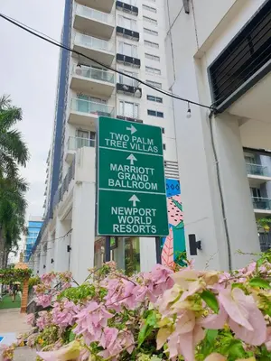 a sign on the side of a building with pink flowers at Layover Stay Condotels at Two Palm Tree Villas in Manila