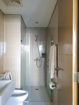 a bathroom with a shower with a toilet and a sink at Layover Stay Condotels at Two Palm Tree Villas in Manila