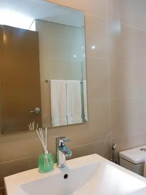 a bathroom with a sink and a mirror and a toilet at Layover Stay Condotels at Two Palm Tree Villas in Manila