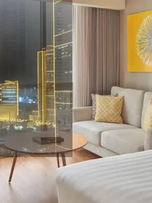 a living room with a couch and a glass table at Novotel Rockwell View Hotel Residences in Manila