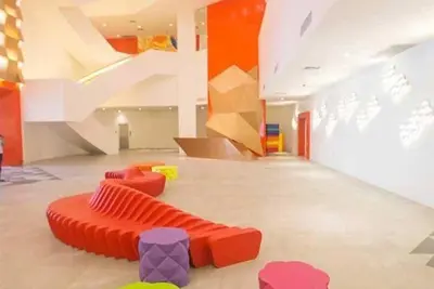 a living room with a red couch and stairs at Novotel Rockwell View Hotel Residences in Manila