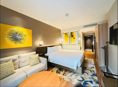 a hotel room with a bed and a couch at Novotel Rockwell View Hotel Residences in Manila